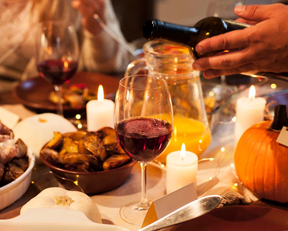 Gros plan des mains versant du vin lors d'un dîner